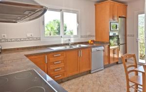 een keuken met houten kasten en een spoelbak bij Villa The Pond in Sant Josep +15 foto's