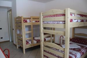 a room with three bunk beds in a room at Casa Corti Ostello Ristorante in Valbondione