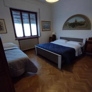 a bedroom with two beds and a large window at Casa Ugo in Poppi