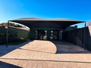 a building with a canopy over a brick driveway at Boutique On Madeliefie in Welkom