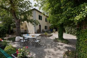 a patio with a table and chairs in front of a building at Timeless Elegance in Poggibonsi