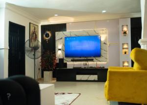 sala de estar con TV grande en la pared en 2 Bedroom Luxury Apartment with Pool -24Hrs Power -PS4, en Lagos