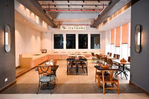 a restaurant with tables and chairs and a large window at Alivaa Hotel Gurugram Sohna Road City Center in Gurgaon