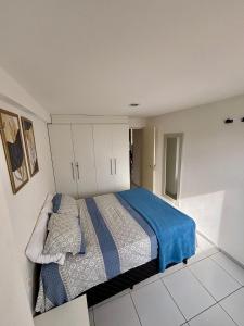 a bedroom with a large bed with a blue blanket at Apartamento Amplo - Ideal para famílias in João Pessoa +24 photos