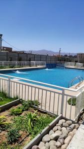 a large swimming pool with a white fence around it at la serena 1 dormitorio in La Serena