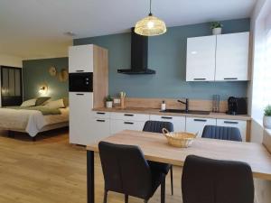 a kitchen and dining room with a table and a bed at Gîte du moulin in Marpent