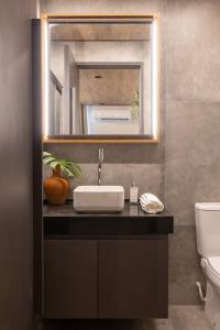 ein Badezimmer mit Waschbecken und Spiegel in der Unterkunft beira-mar pajuçara in Maceió