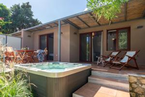a hot tub on the deck of a house at Klaritz Luxury Suites in Lassi