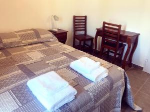 a bedroom with two beds and a table and two chairs at Posta Almendros Apart in Merlo +30 photos