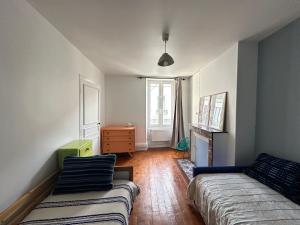 a living room with a bed and a couch at Maison familiale-jardin-50m du Loing-tout à pieds in Moret-sur-Loing