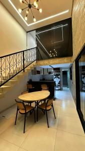 a dining room with a table and chairs and a staircase at Loft Adélia in Triunfo +11 photos