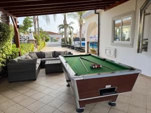 un tavolo da biliardo su un patio con divano e tavolo da biliardo. di Sunset Villa private complex heated pool a Ayia Napa