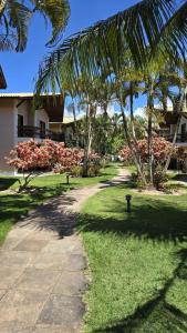 une allée avec des palmiers dans un parc dans l'établissement Casa Lírio - Beira da praia, à Porto Seguro