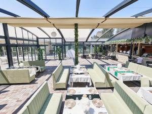 a restaurant with tables and chairs in a building at Hotel EMD in Bacău