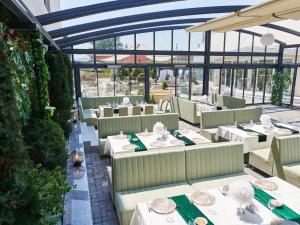 an empty restaurant with white tables and chairs at Hotel EMD in Bacău