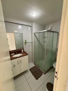a bathroom with a glass shower and a sink at Apartamento Amplo - Ideal para famílias in João Pessoa