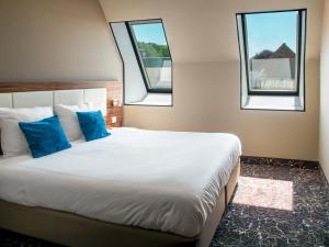 a bedroom with a large bed with two windows at Amsterdam Lake Hotel in Badhoevedorp