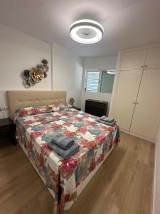 Un dormitorio con una cama con un edredón floral. en The pool balcony Playa las Americas, en Csta Adje 16 fotos más