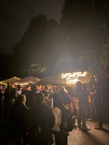 a crowd of people standing in front of a food truck at Løst Souls Oktoberfest Campsite in Munich