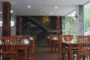 a restaurant with wooden tables and chairs and a staircase at Hotel City Grand Ella in Ella +39 photos