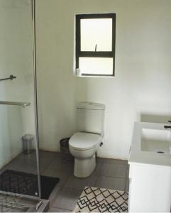a bathroom with a toilet and a sink at Peter's Gate Farm Cottage in Lidgetton +26 photos