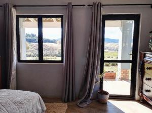 a bedroom with a bed and a large window at Peter's Gate Farm Cottage in Lidgetton