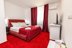a bedroom with a bed with a red carpet at Boutique Boema in Târgovişte
