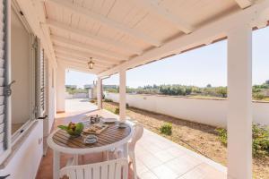 a patio with a table and chairs on a balcony at Apartments In Golfo Orosei in Orosei