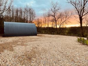 Watch House VillageExecutive Pod and Jacuzzi的一个巨大的金属物体静静地躺在砾石地上。