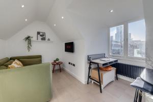 a living room with a couch and a table at 1 Bedroom Penthouse Apartment - Shoreditch, London by The Perfect Stay in London