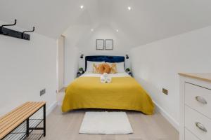 a bedroom with a yellow bed with a teddy bear on it at 1 Bedroom Penthouse Apartment - Shoreditch, London by The Perfect Stay in London