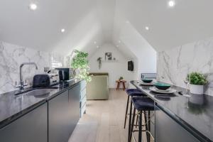 a kitchen with marble counter tops and stools at 1 Bedroom Penthouse Apartment - Shoreditch, London by The Perfect Stay in London