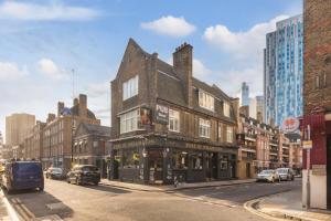 an old building on the corner of a city street at 1 Bedroom Penthouse Apartment - Shoreditch, London by The Perfect Stay in London