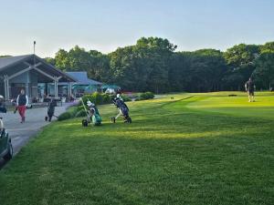 two children playing in the grass on a golf course at Brand New 4BR House 20Min Downtown Boston in Boston