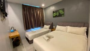 阿罗士打G9 Hotel Alor Setar的有两张床、一张书桌和一扇窗户的房间