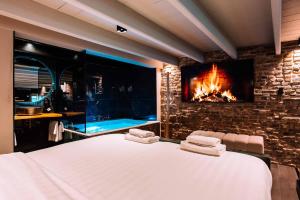 a bedroom with a fireplace and a bed with towels at City Spa Nijmegen in Nijmegen