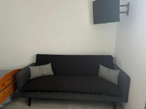 a black couch sitting in a corner of a room at Casa Lucas dos in Almáciga