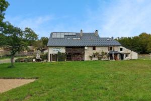 a large house with a large grassy yard at La Grange des Plans in Le Grand-Abergement