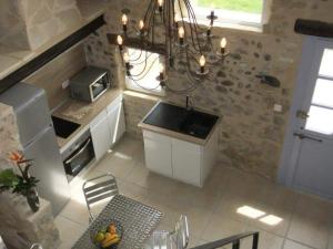 a kitchen with a chandelier and a table with a chair at Gîte de Lou Mas in Savasse
