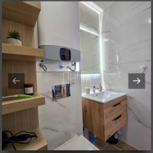 a white bathroom with a sink and a mirror at D&D Apartman Jahorina in Jahorina +5 photos
