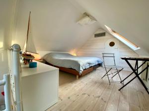 ein Schlafzimmer mit einem Bett und einem Schreibtisch auf einem Dachboden in der Unterkunft Riquette in Le Touquet-Paris-Plage