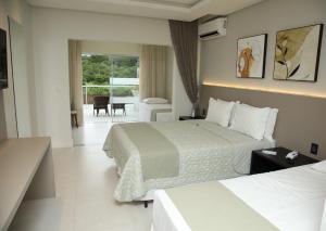 a hotel room with two beds and a balcony at Resort Ecoar in Gaspar +109 photos