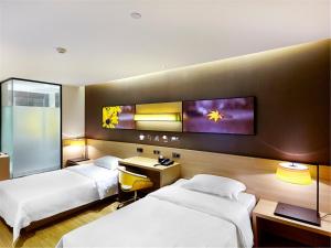 a hotel room with two beds and a tv on the wall at 7Days Inn Premium Beijing Chaoyangmen in Beijing