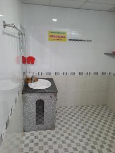 a bathroom with a sink in a tile floor at Khách Sạn Trường Thịnh in Ben Tre +41 photos