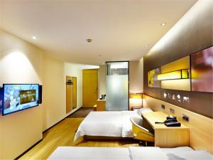 a hotel room with two beds and a tv at 7Days Inn Premium Beijing Chaoyangmen in Beijing