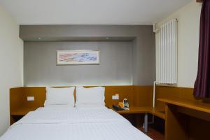 a bedroom with a large bed with white sheets at 7Days Inn Premium Beijing Chaoyangmen in Beijing +13 photos