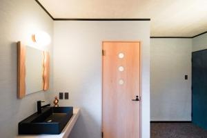 a bathroom with a sink and a mirror at Time Harbor Hakuba in Hakuba +61 photos