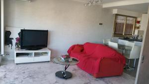 salon z czerwoną kanapą i telewizorem w obiekcie Moderne Appartement Cannes Californie w Cannes