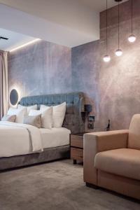 a bedroom with a large bed and a chair at Hotel Simona Halep - Poiana Brasov in Poiana Brasov +54 photos