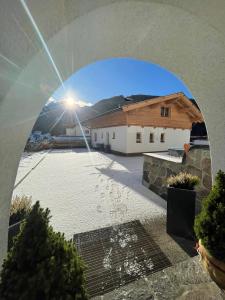 a view through a window of a house with a driveway at Chalet Andreashof in Gerlos